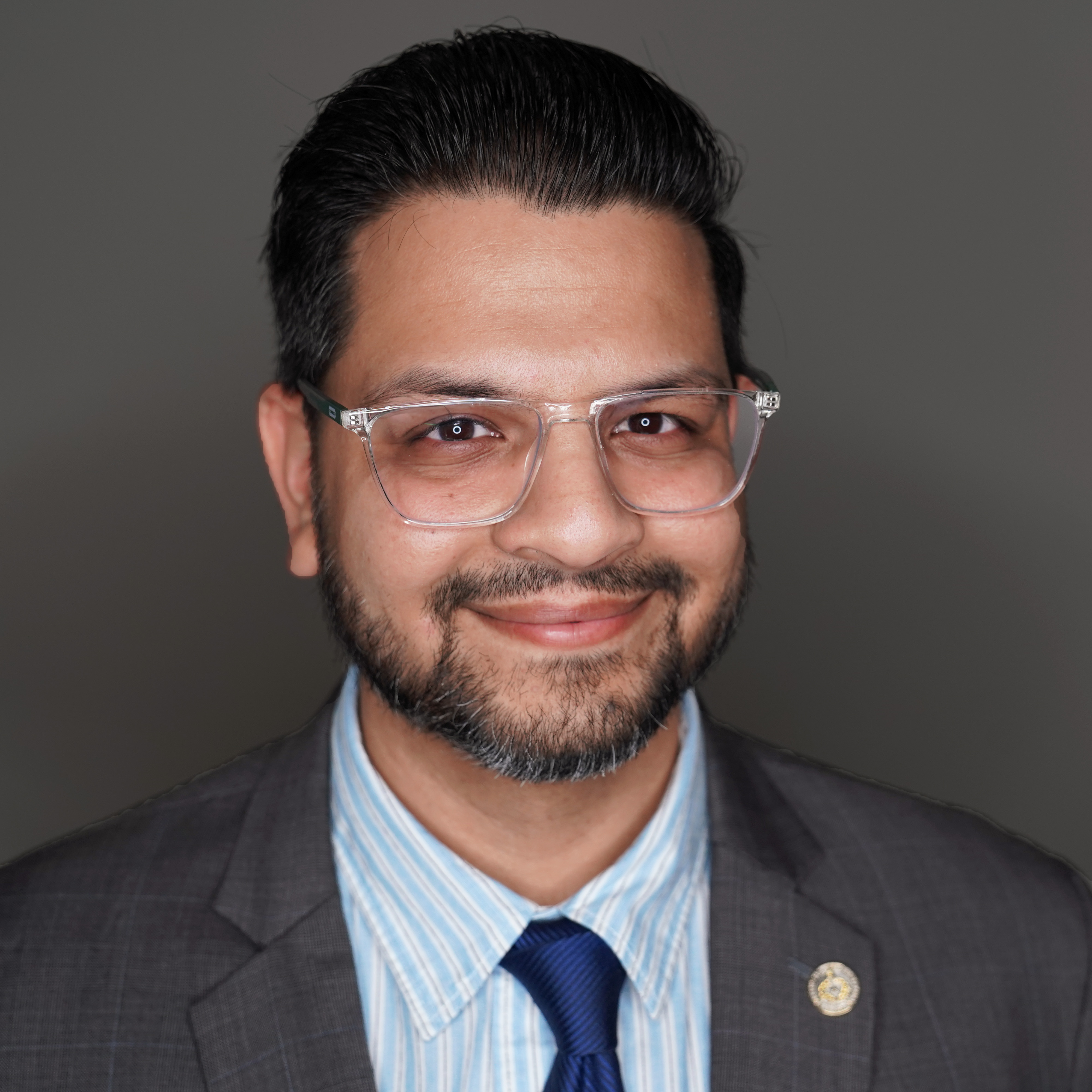 Chief of Staff Ali Hasanali headshot with dark background