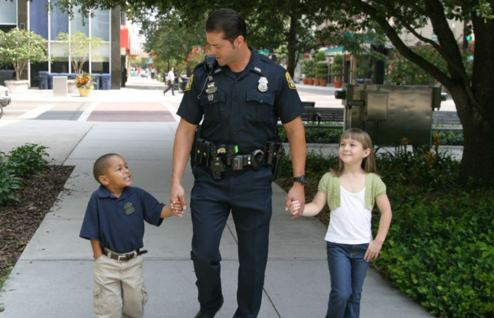 officer escorting children